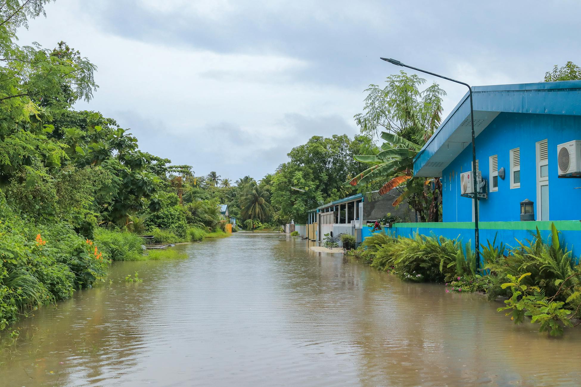 A tropical street in Nolhivaranfaru, Maldives, submerged due to flooding.