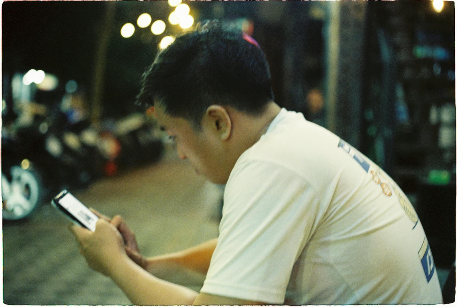 person texting alone evening