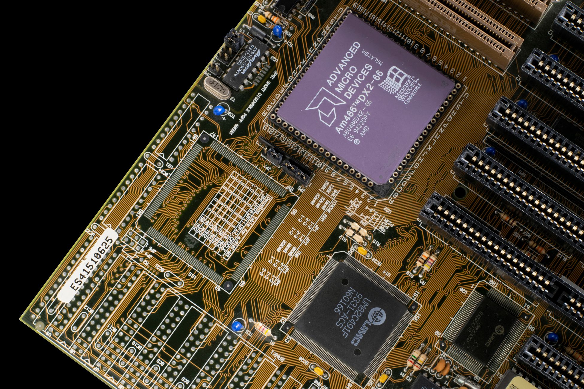 Detailed view of a vintage motherboard with microchips and circuits, showcasing retro technology.