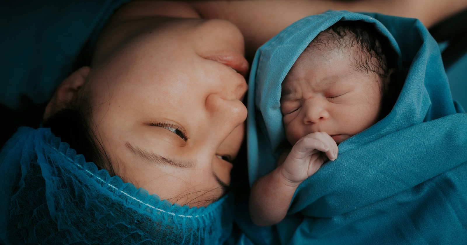 Mother lying beside a newborn baby