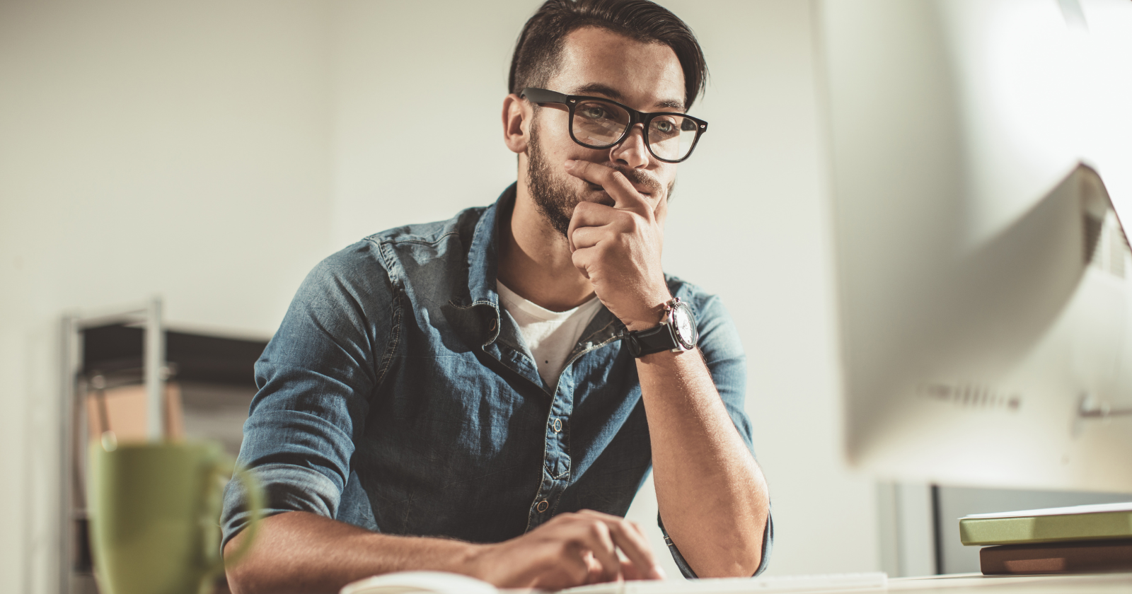 Thoughtful man with glasses at a desk