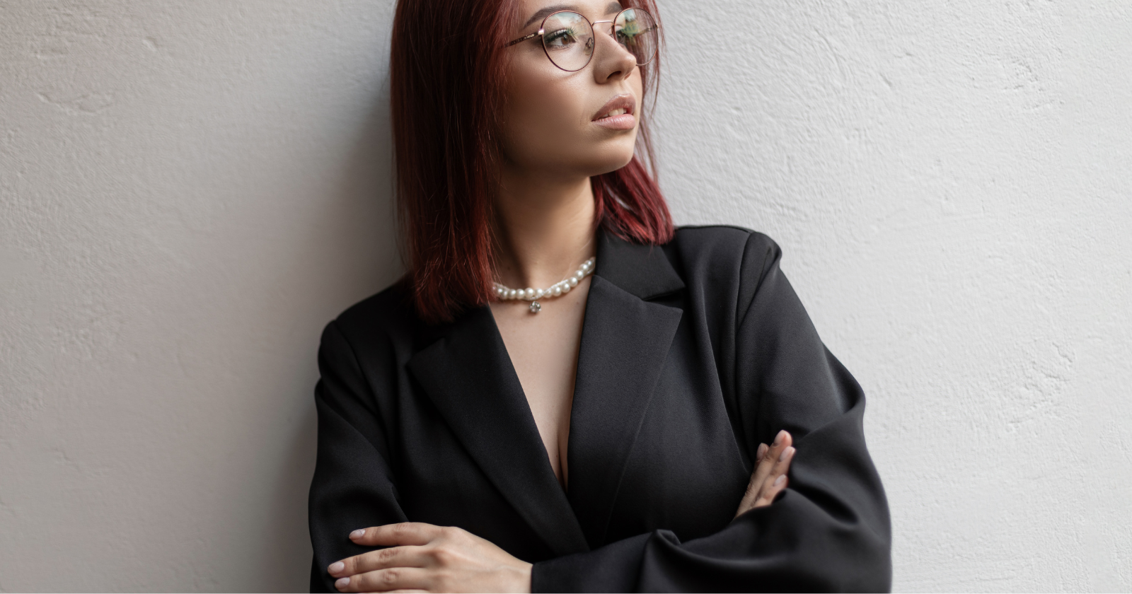 Woman in a black suit with her arms crossed
