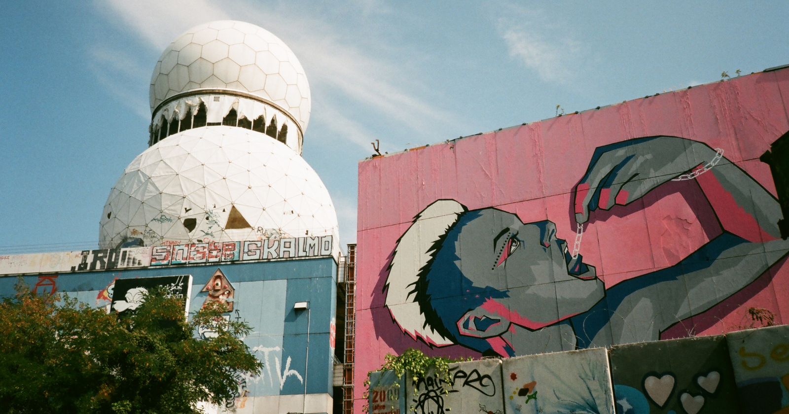 Geodesic radar domes above a graffiti-covered wall