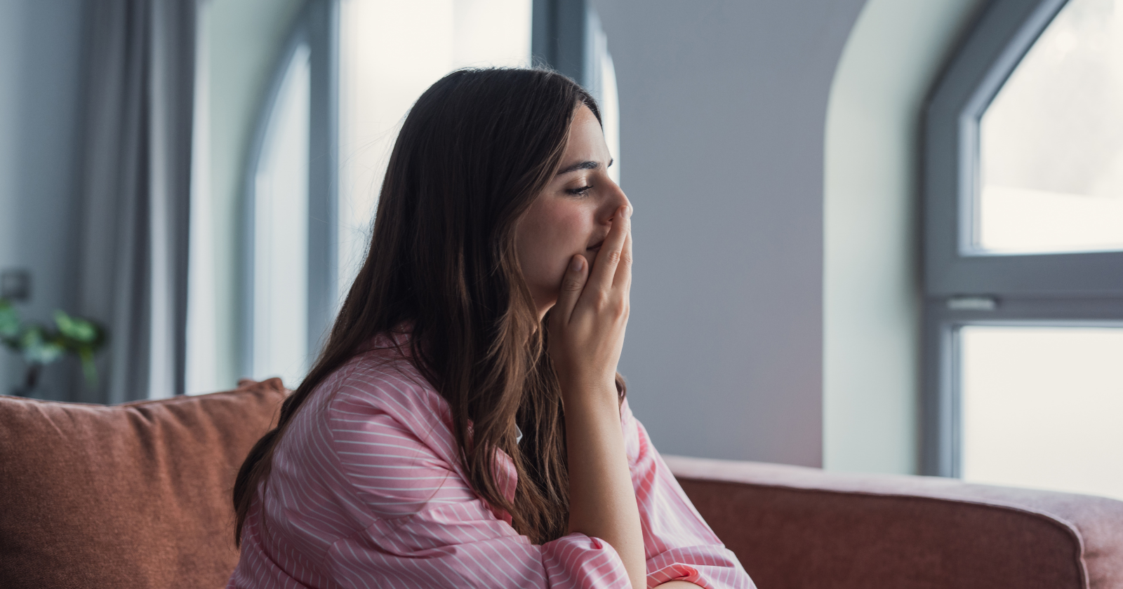 Woman sitting with a hand over her mouth