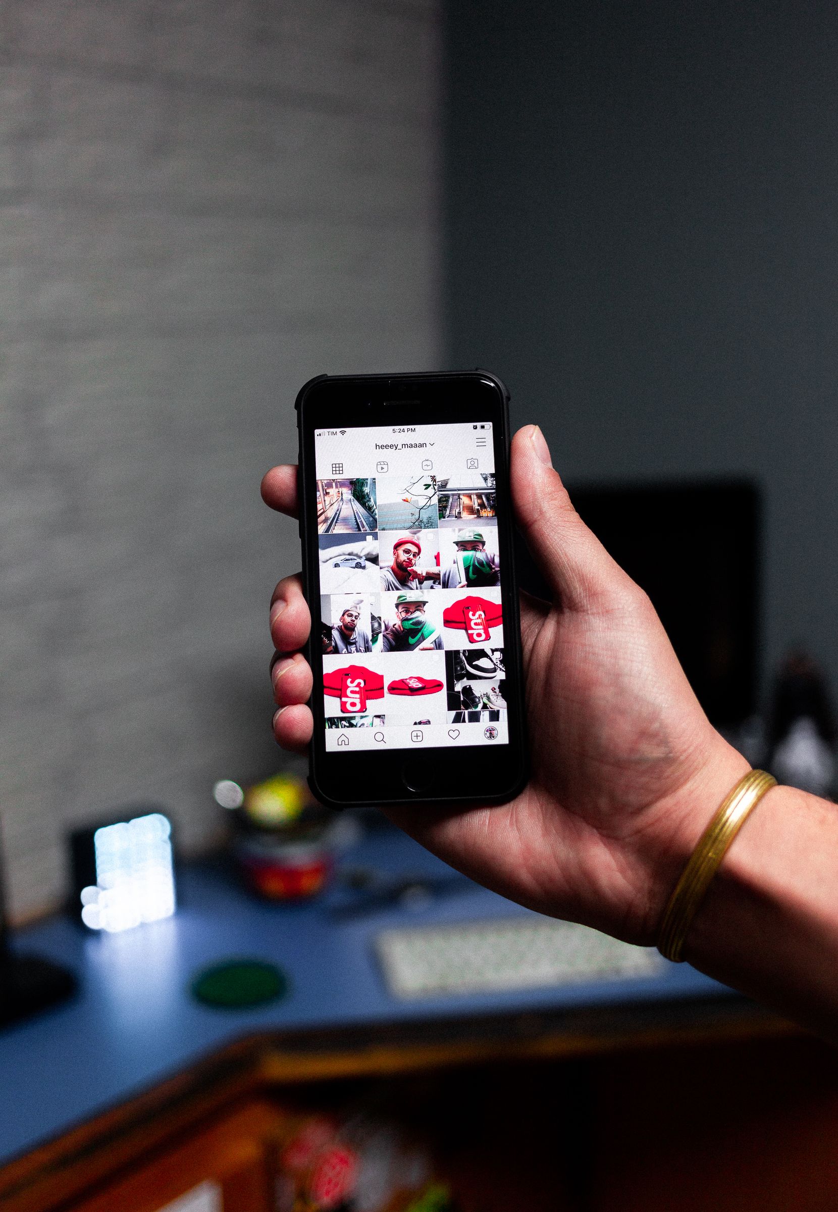A person holding a smartphone displaying an Instagram feed indoors, a representative image and not a photograph of any person discussed in the article.