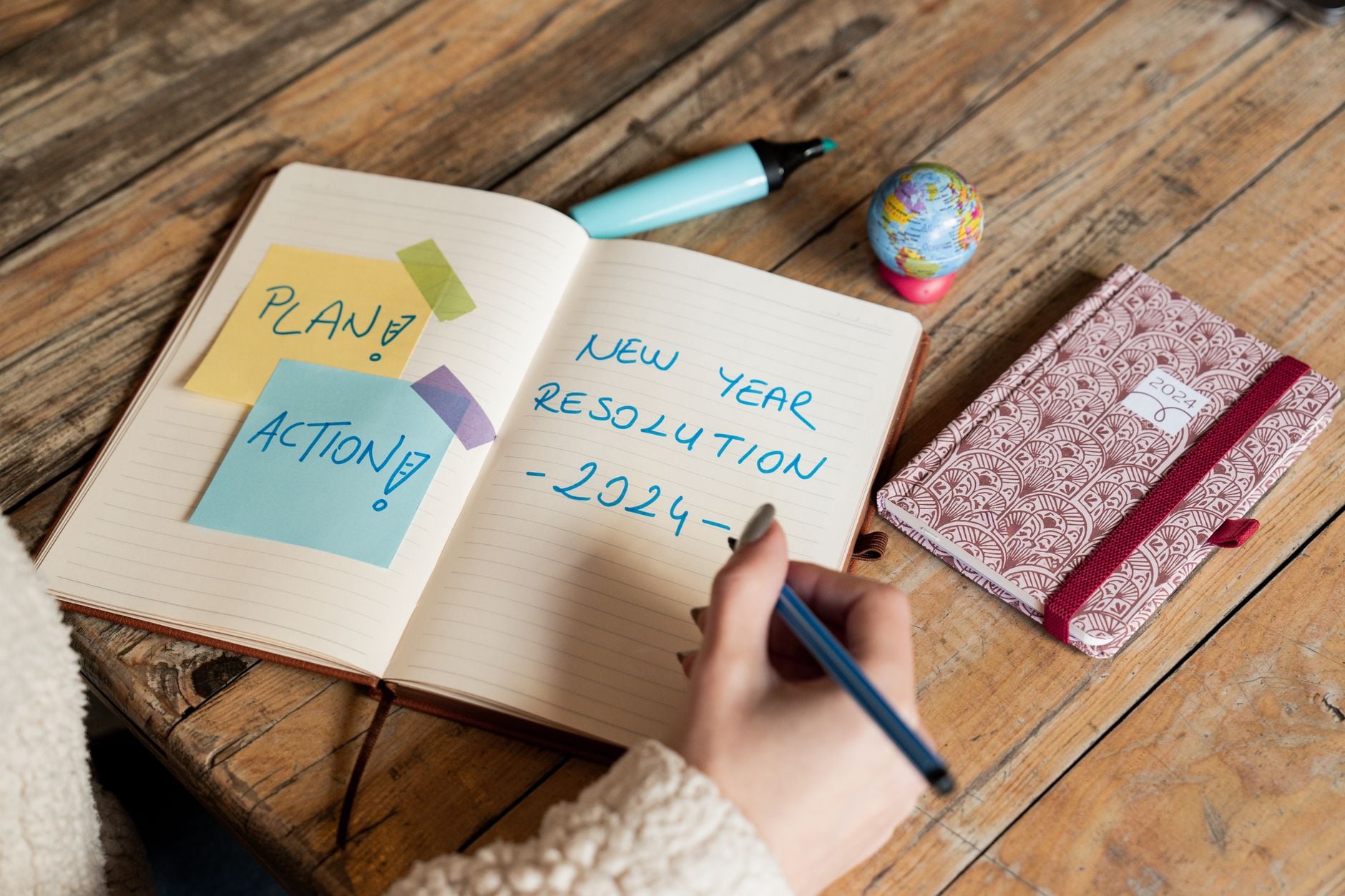 A notebook and pen on a desk, planning self-improvement goals
