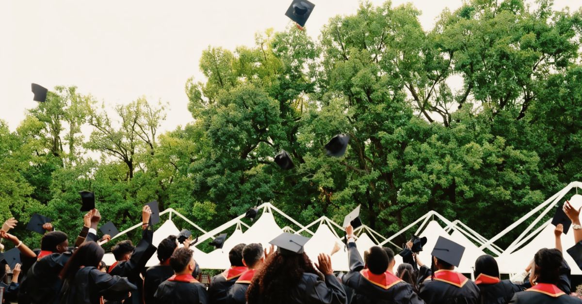 Graduates in caps and gowns throwing their hats