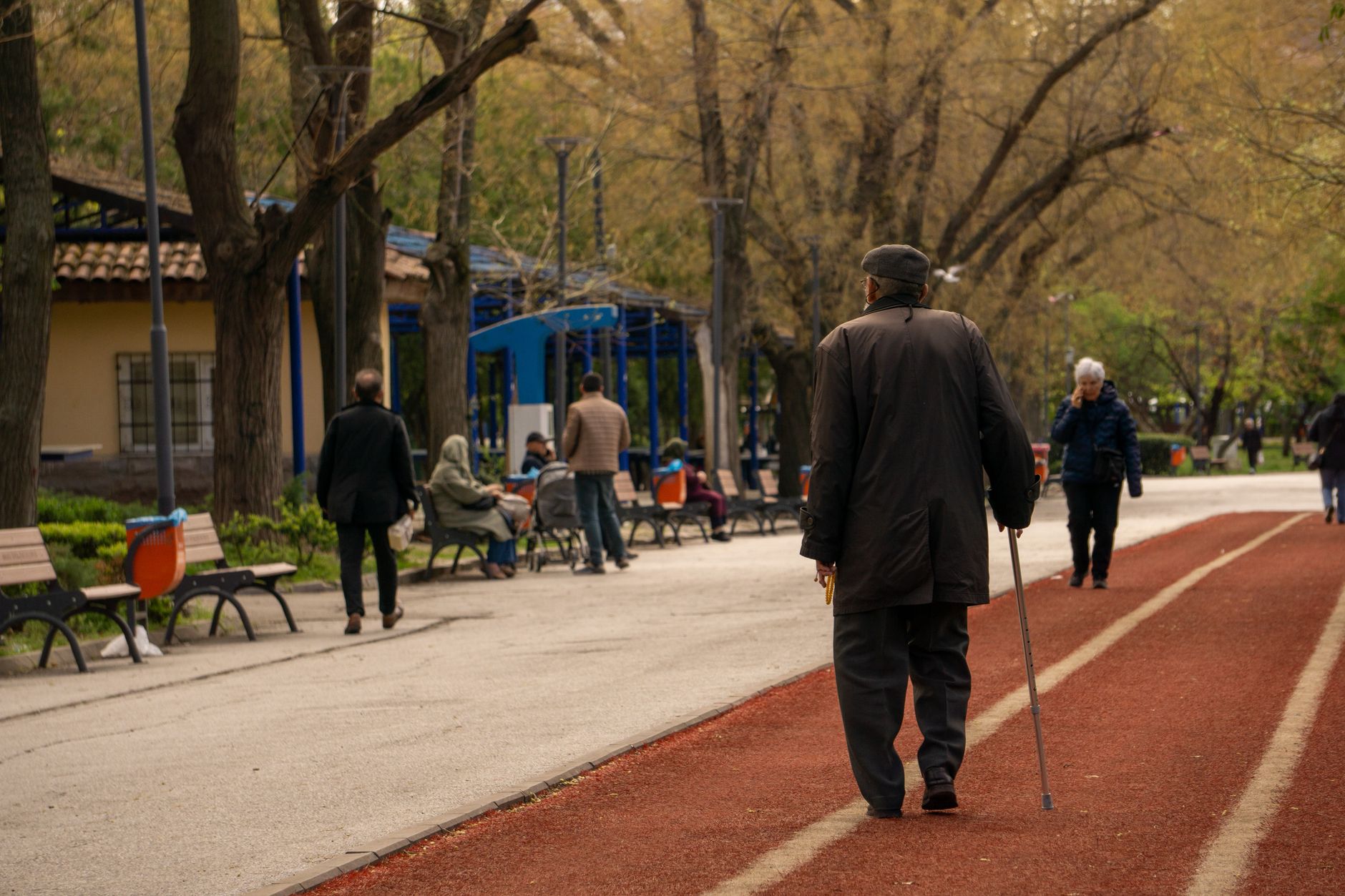 An older adult walking outdoors in warm evening light