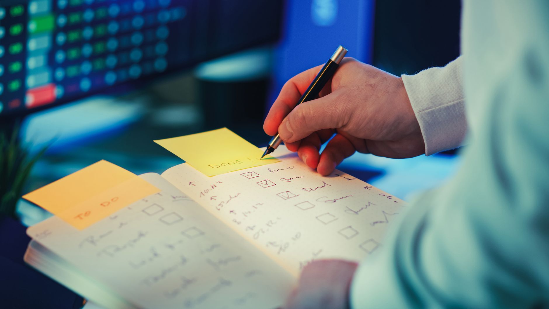 A person marking completed tasks in a notebook checklist