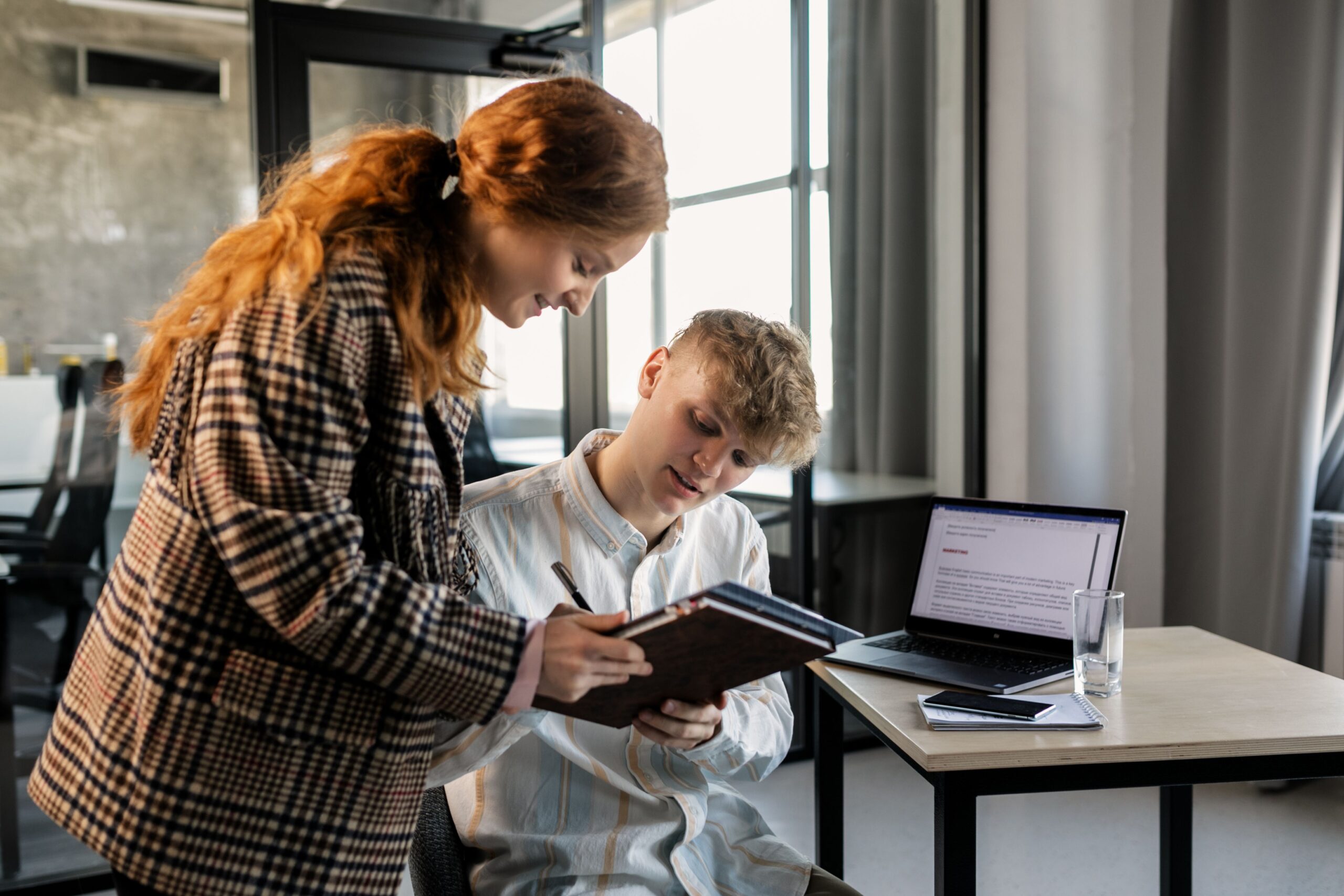 Two people reviewing notes and planning together at a desk
