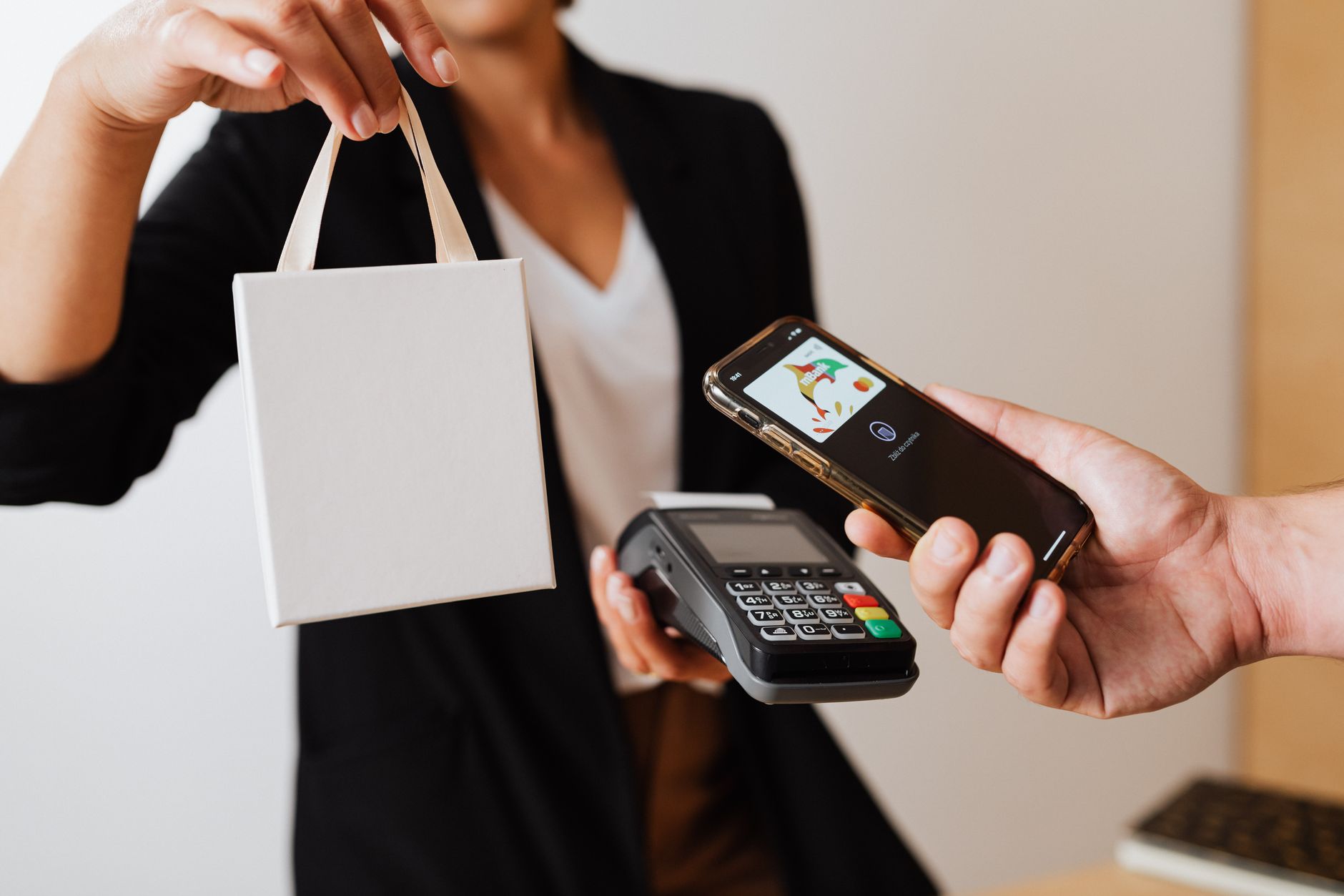 Customer holding a phone over a contactless card payment terminal