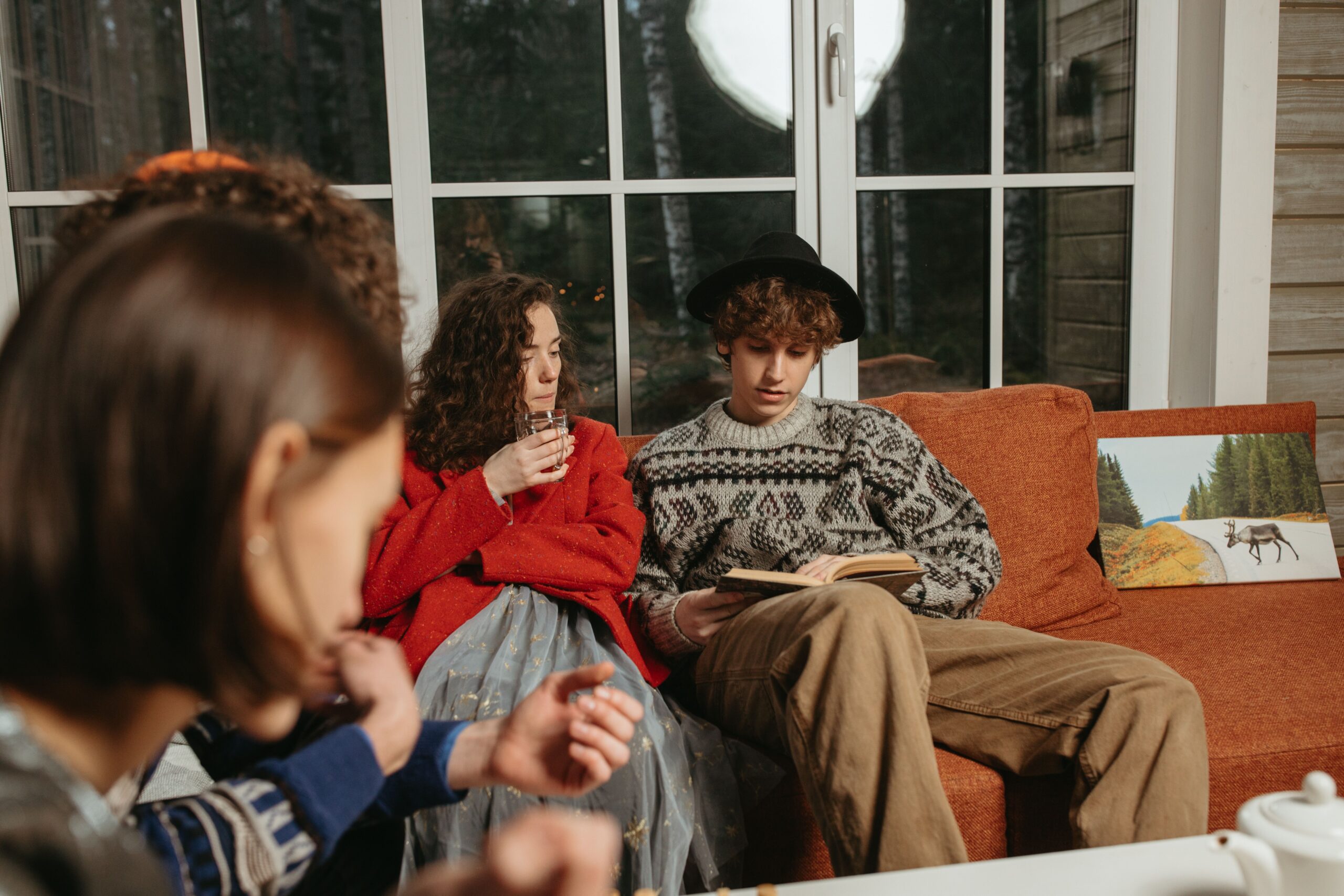 A group of friends spending time together while one person reads a book