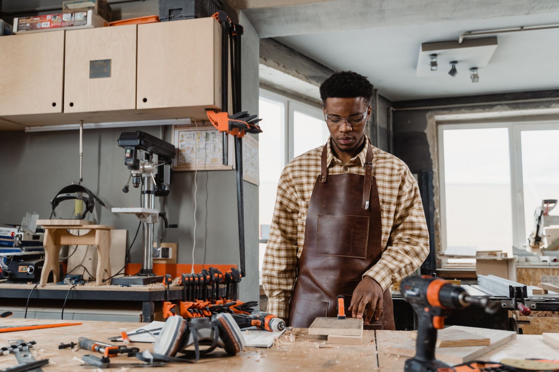 A craftsman concentrating on a woodworking project in a well-equipped workshop
