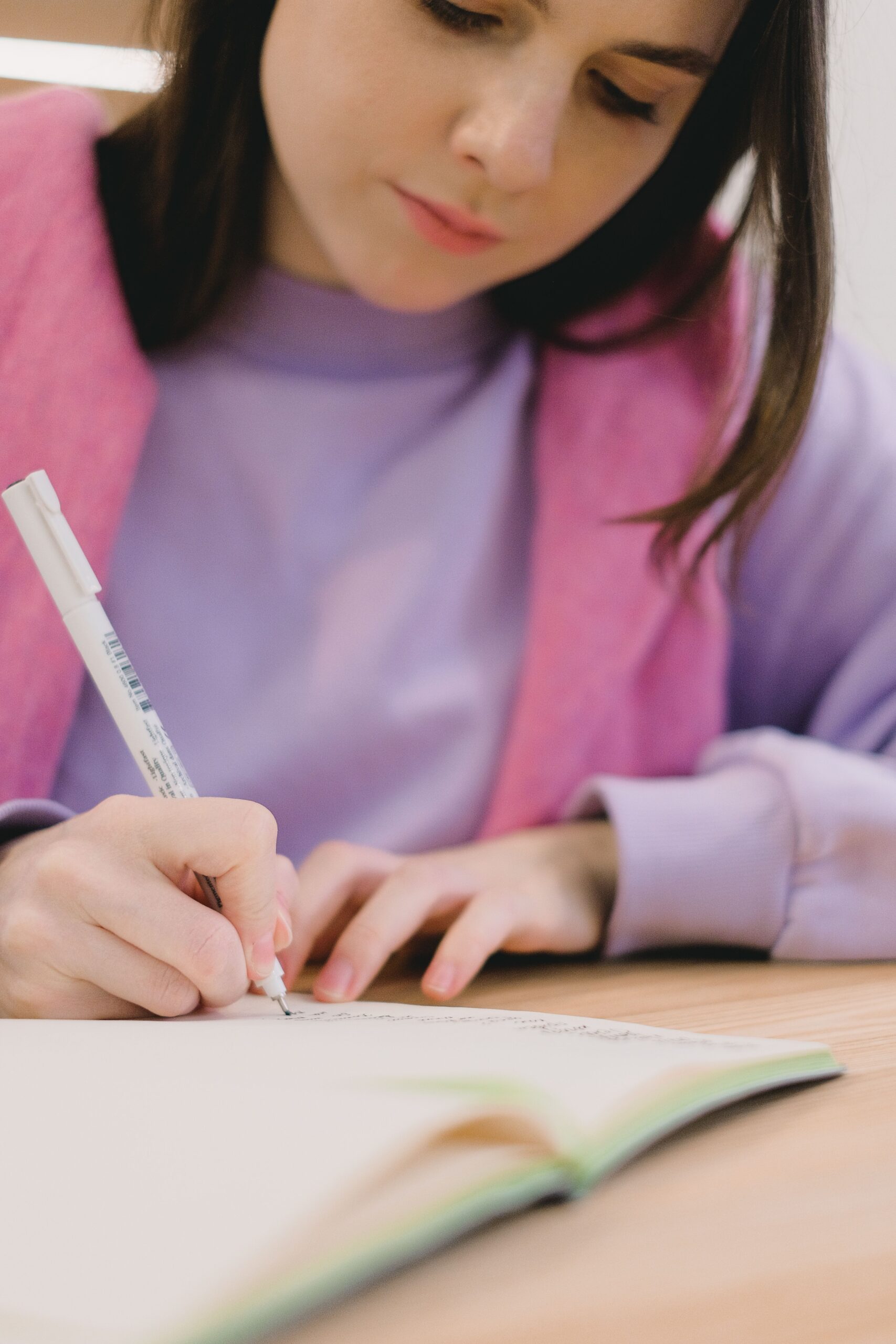 University student writing in a notebook while studying