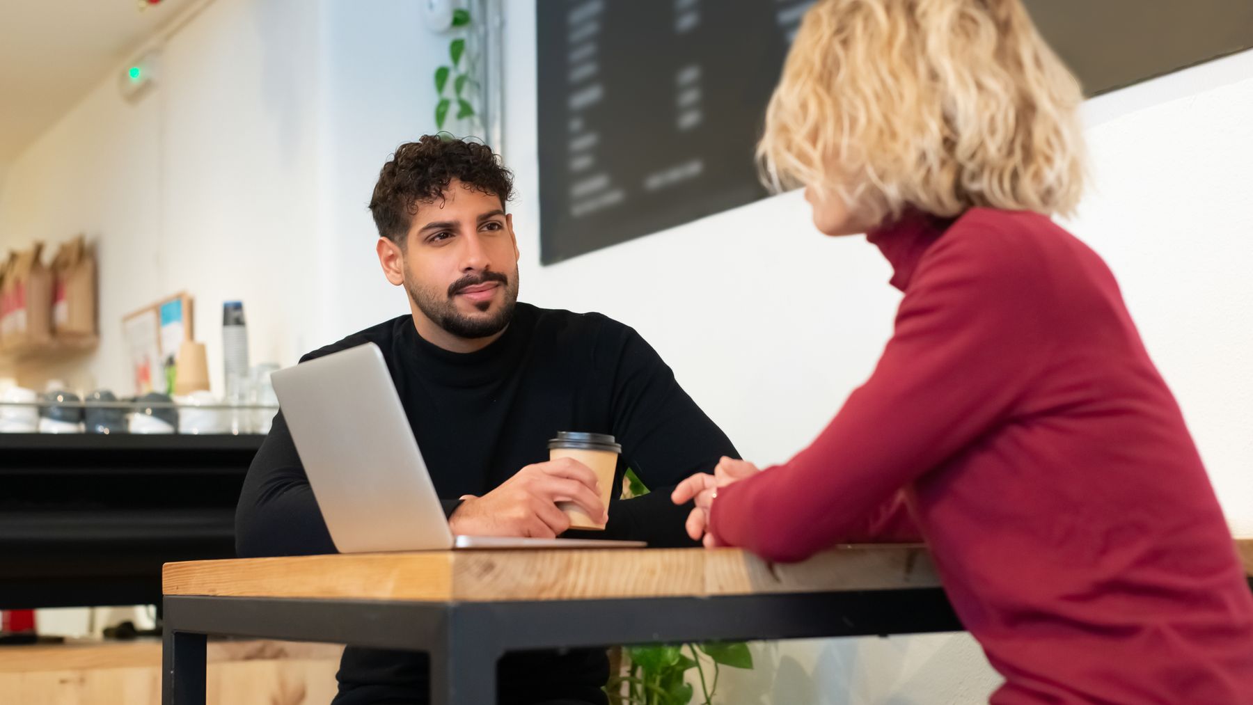 Two adults listening to each other during a conversation in a cafe