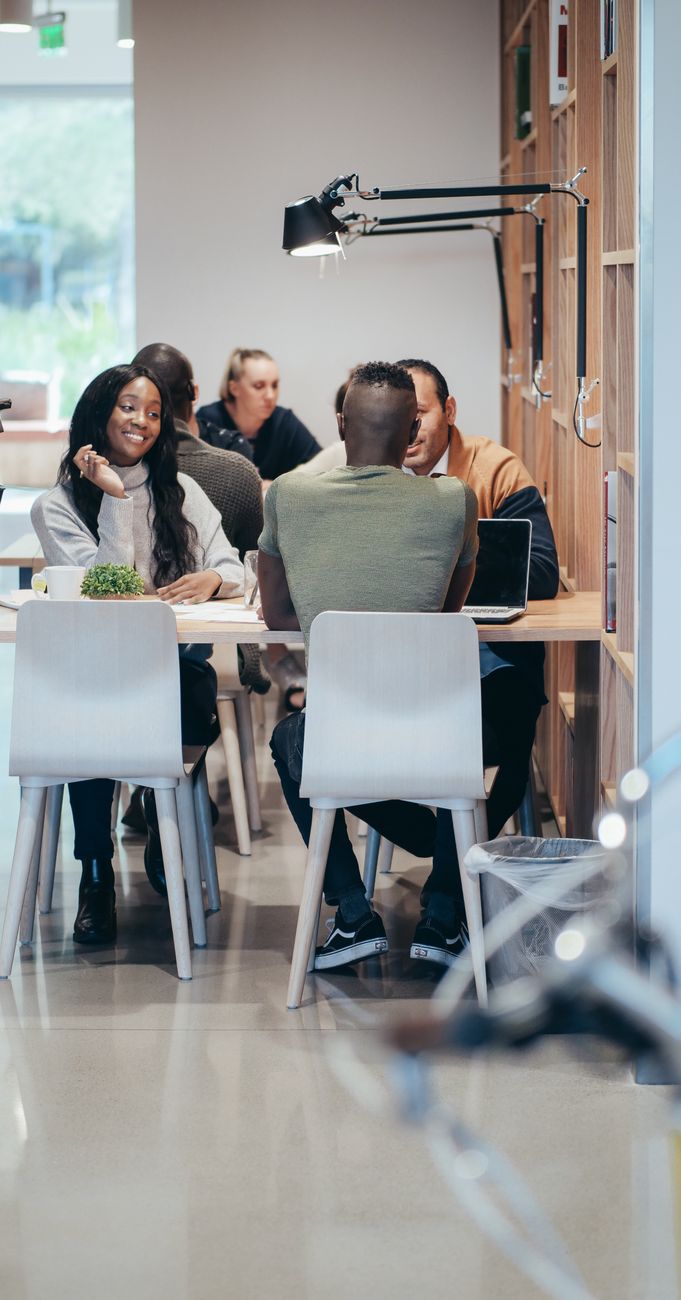 A representative image of a team meeting around a table, not a photograph of any person discussed in the article.