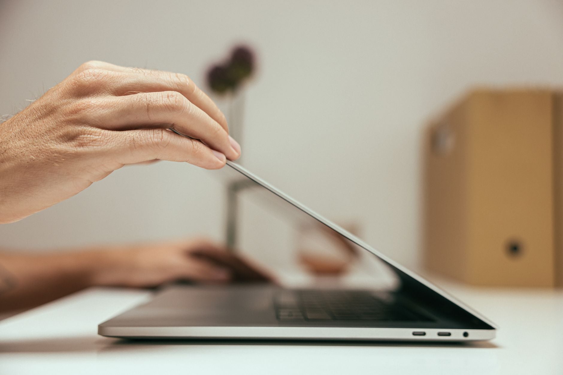 Hand closing a laptop