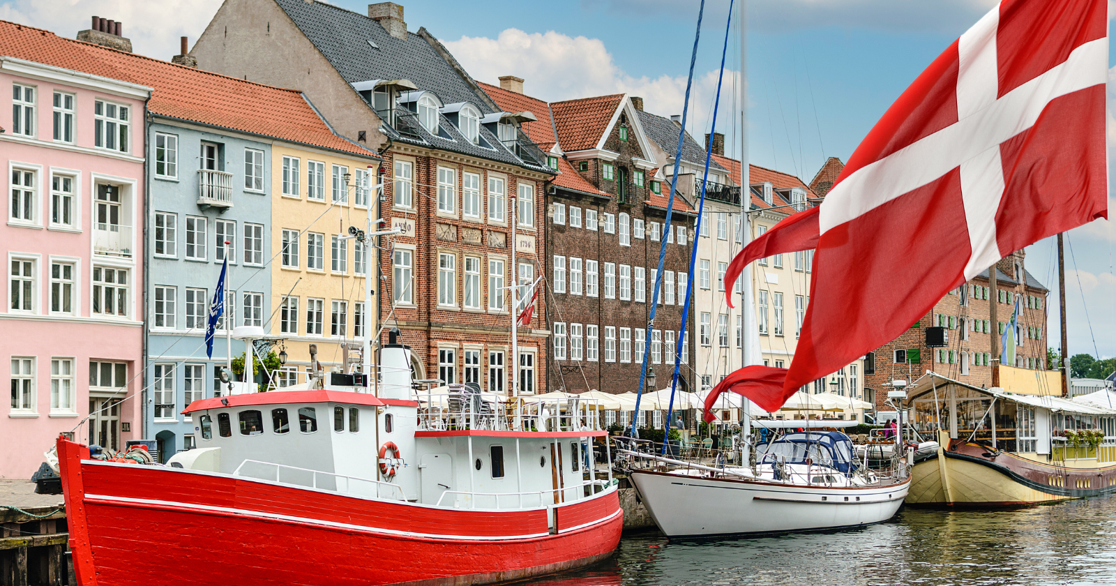 Copenhagen harbour with boats and a Danish flag