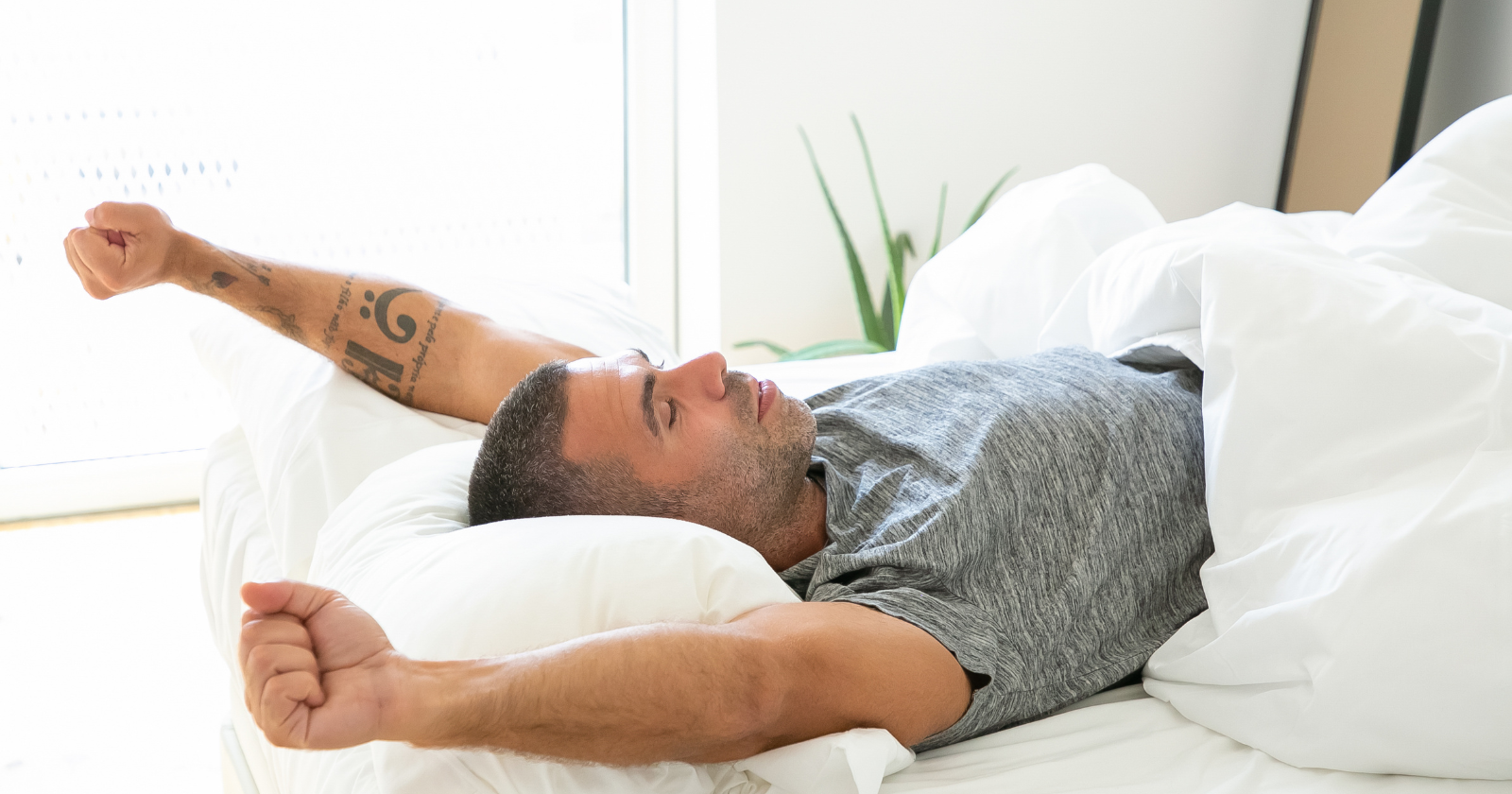 Man stretching after waking in bed