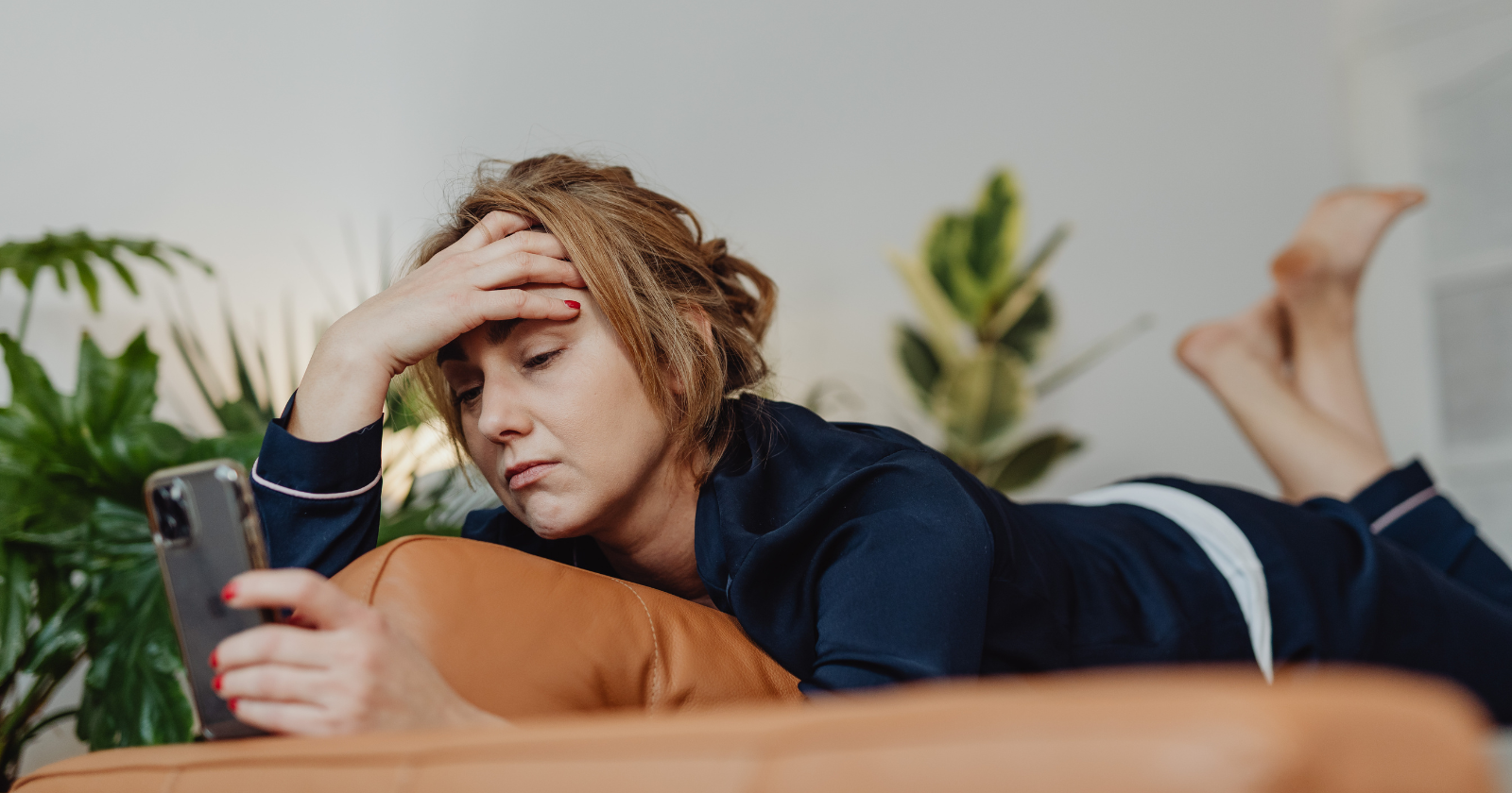 Woman lying on a sofa looking at her phone