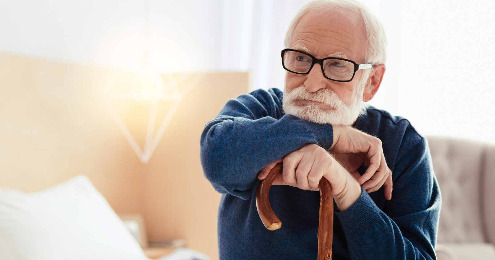 Older man with glasses resting his arms on a walking cane