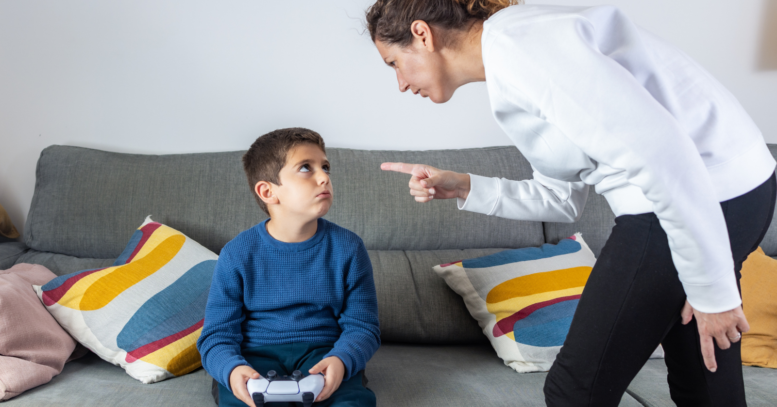 Mother scolding a boy holding a game controller