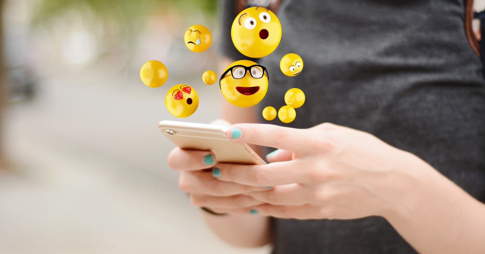 Person holding a smartphone beneath floating emoji icons