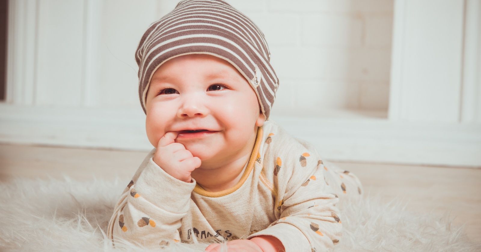 Smiling baby wearing a striped hat