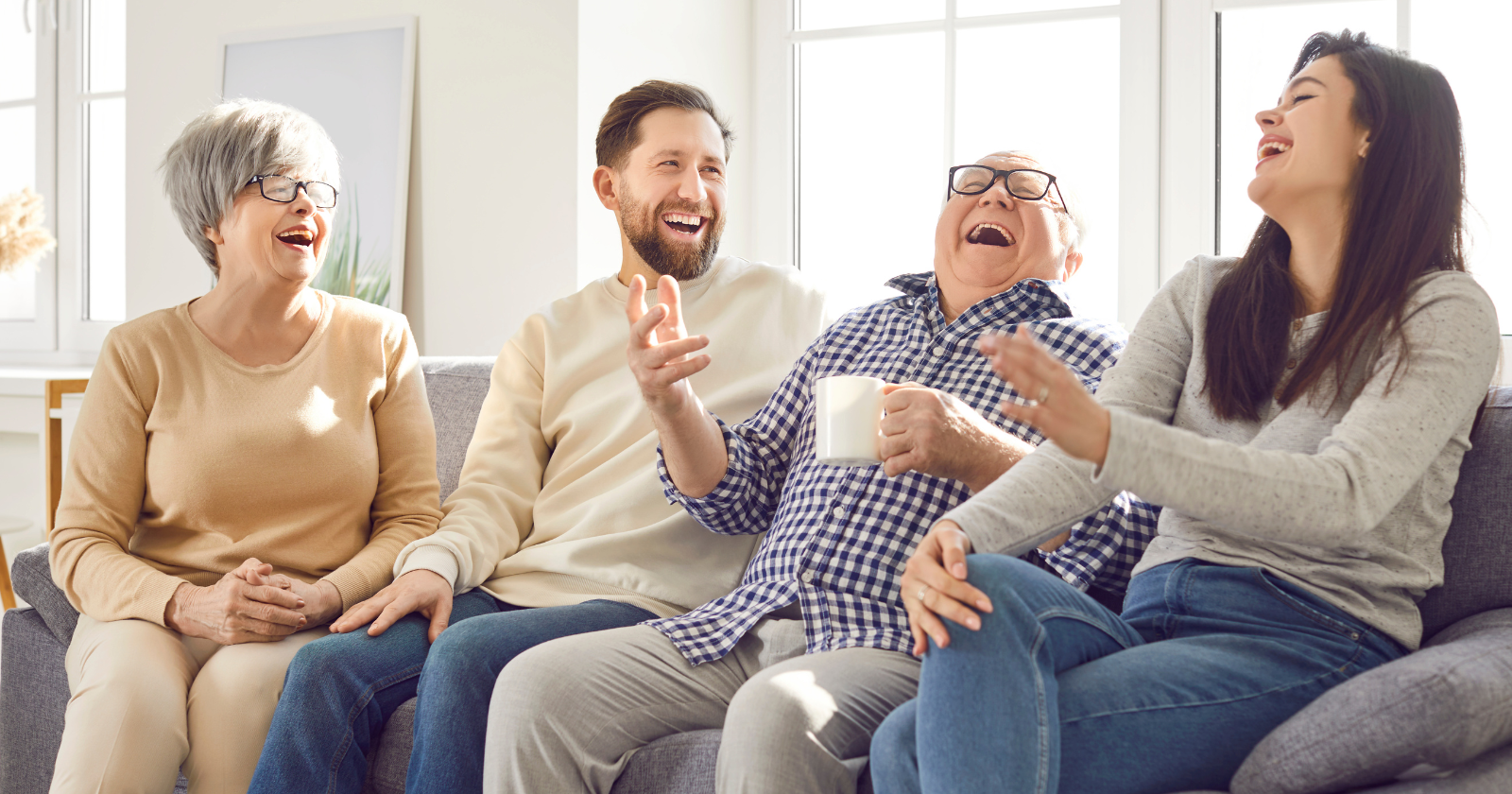 Group of adults laughing together on a sofa
