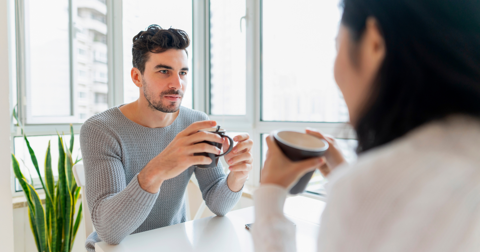 Man and woman talking over cups of coffee