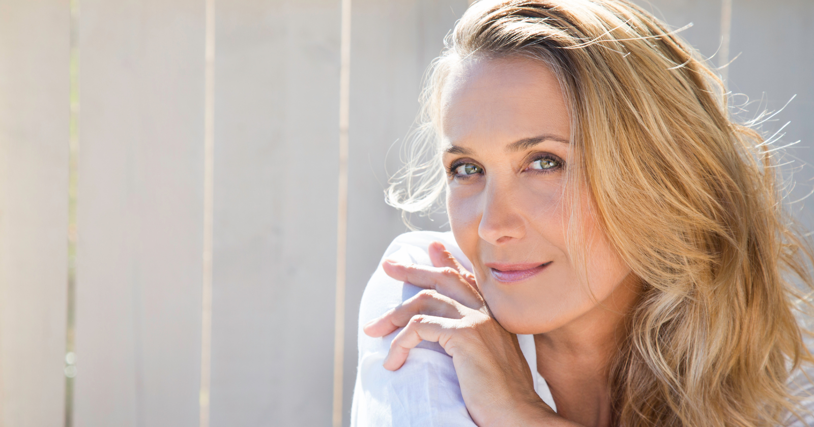 Woman standing beside a bright window