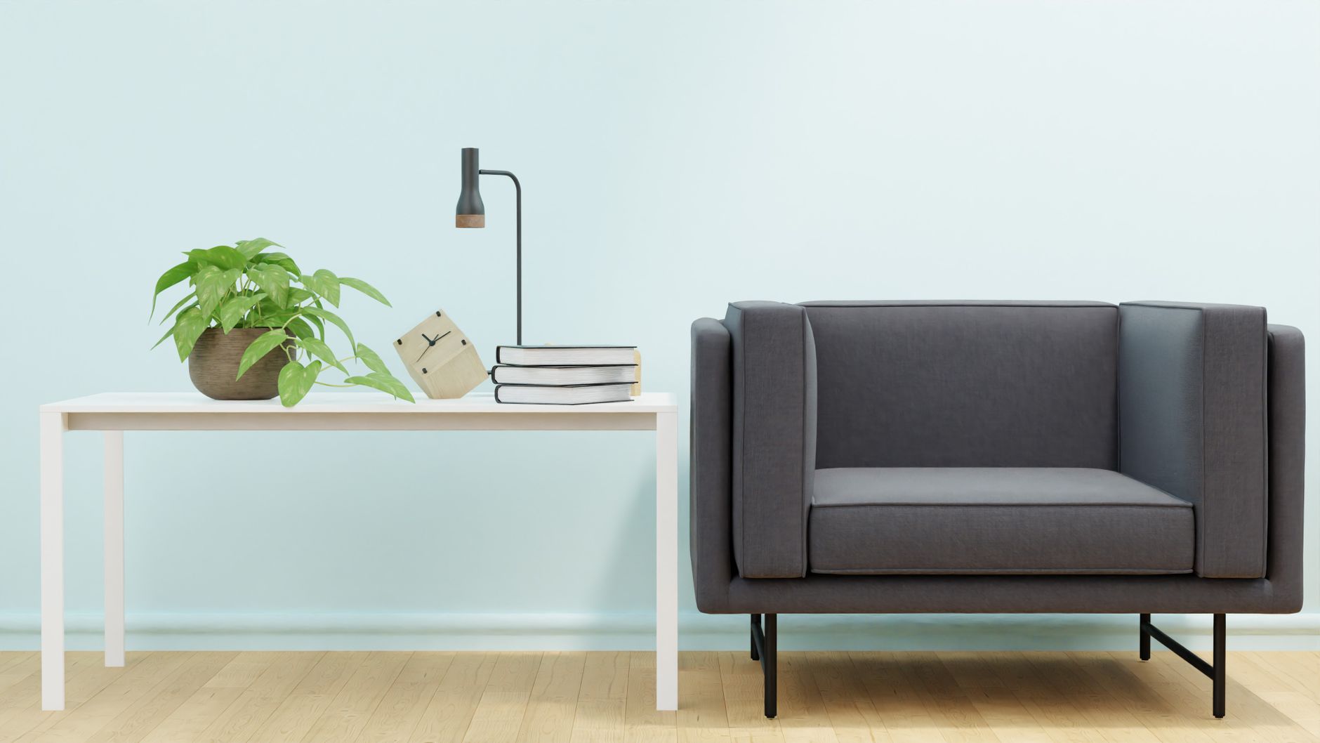 Simple modern living room with a grey sofa, white table, and indoor plant